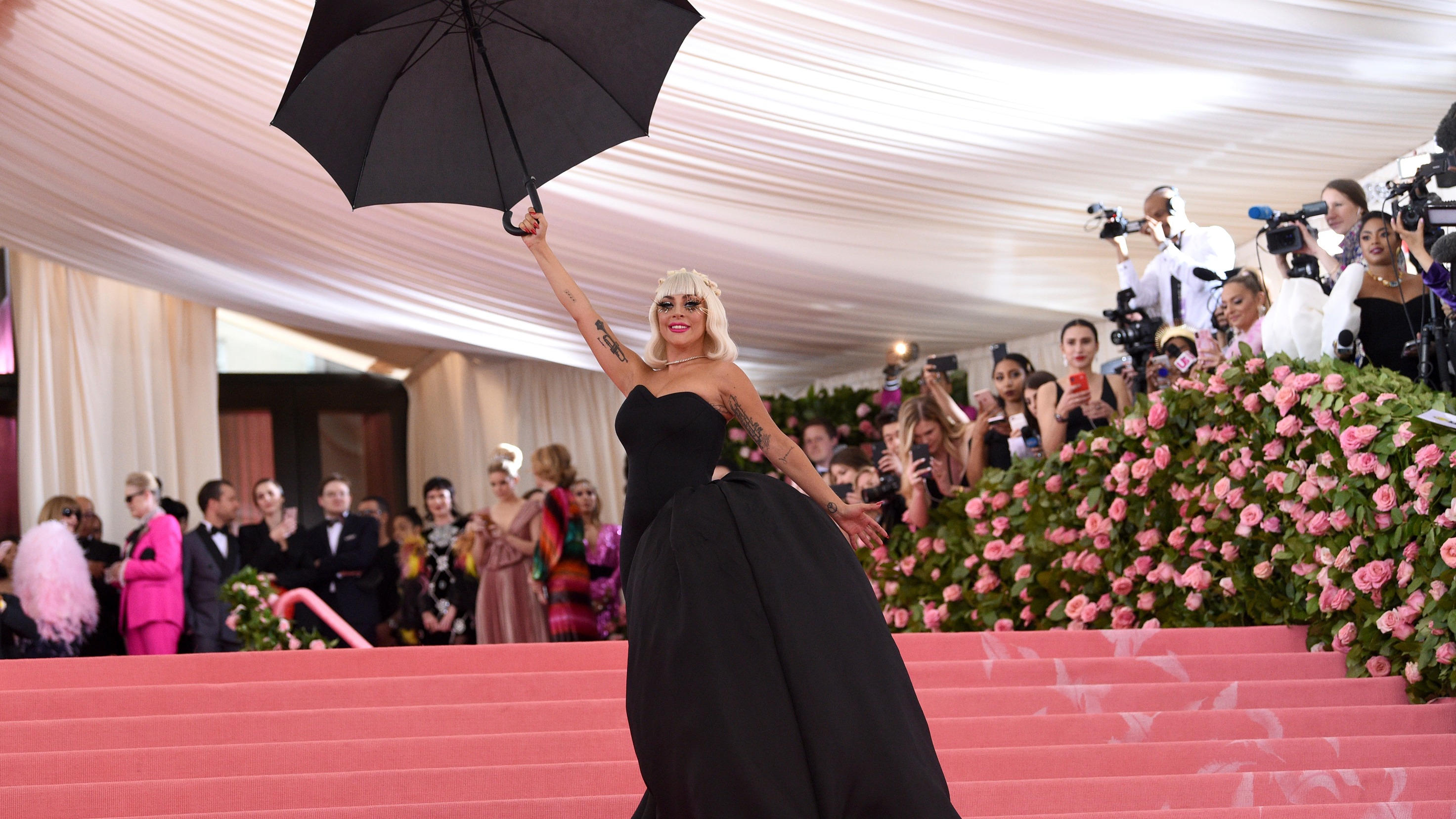 Maxwell le retiró el vestido revelando otro vestido negro asimétrico con una enorme cauda lateral.