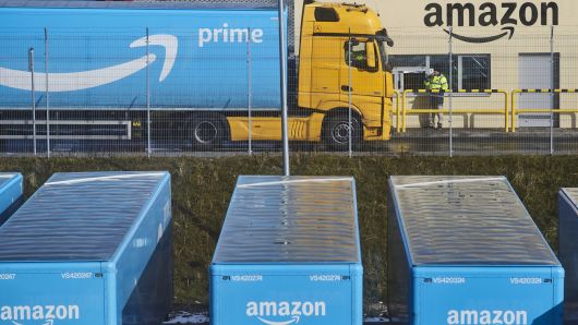 A truck pulling an Amazon Prime branded cargo container waits beside the entrance gate at Amazon.com Inc.
