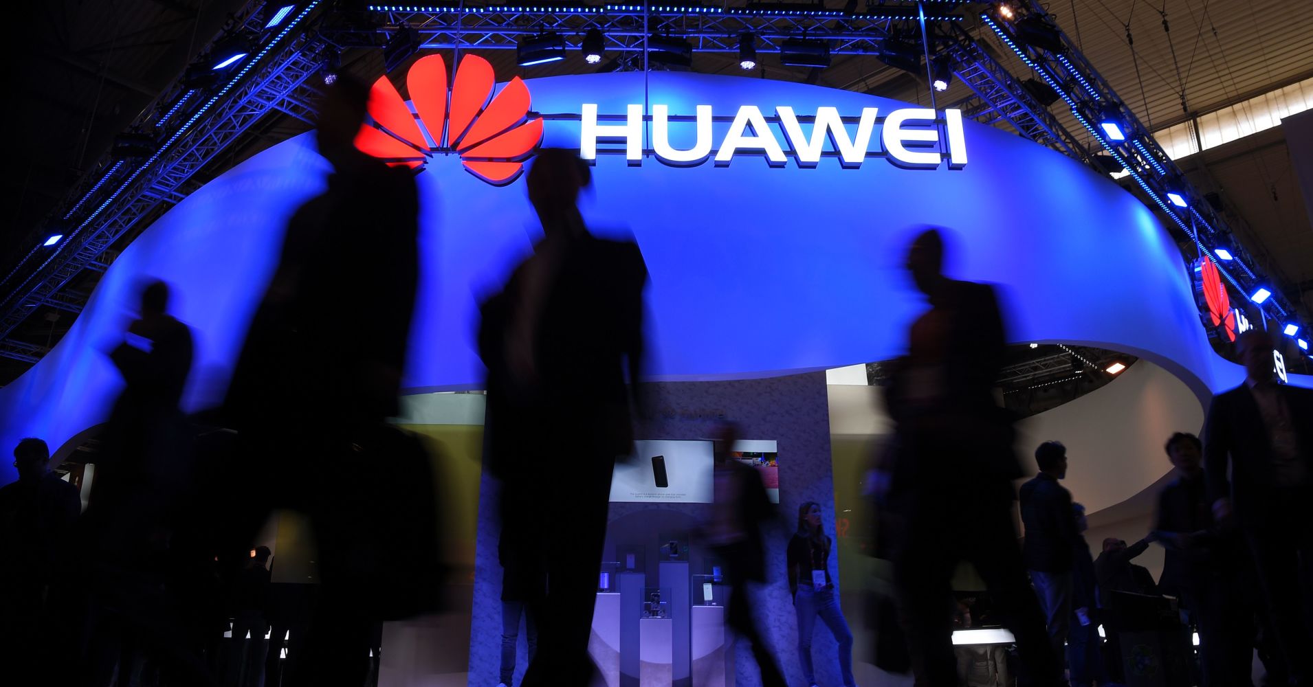 Visitors pass in front of the Huawei's stand on the first day of the Mobile World Congress in Barcelonaon on February 27, 2017 in Barcelona.
