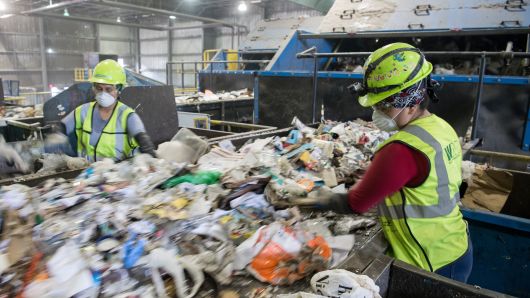 Workers sort recycling material at the Waste Management Material Recovery Facility in Elkridge, Maryland, June 28, 2018. 